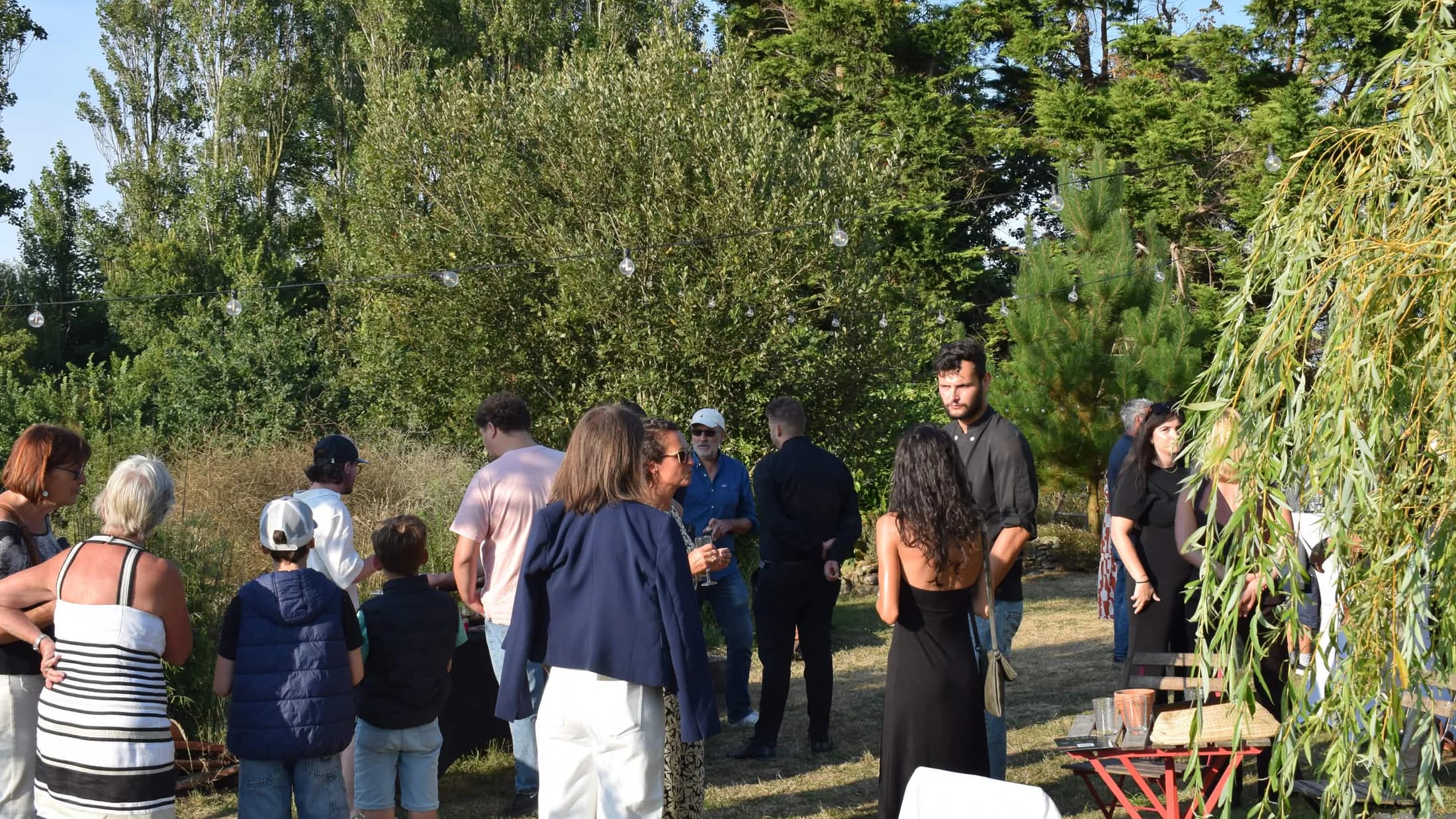 Public intergénérationnel réuni dans le jardin à Henvic